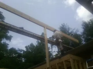 Carpenter setting a ridge beam over a new addition frame — Ice Dam Removal by Roofing Brothers in Lisbon Falls
