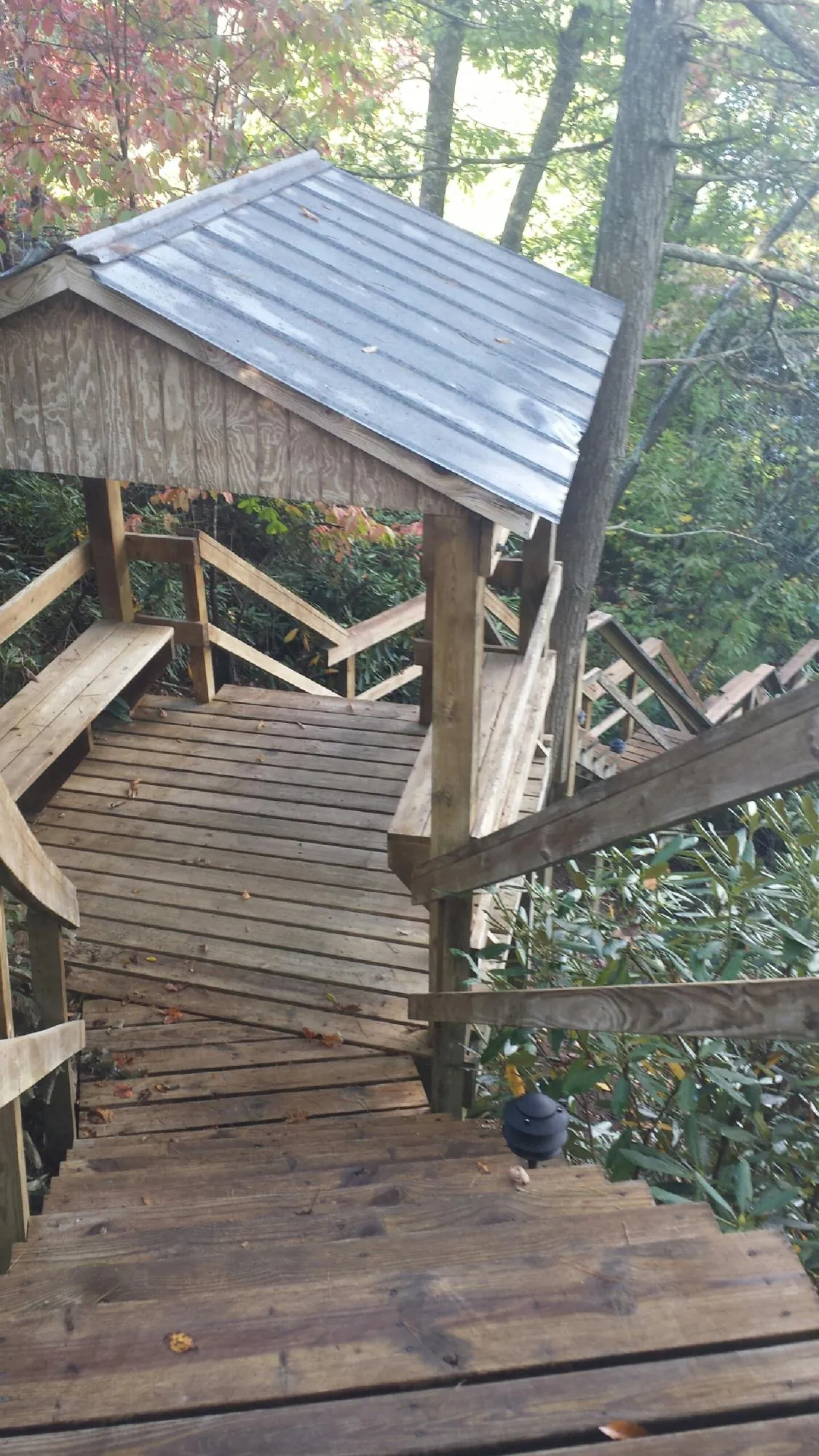 Metal roofed shelter over wooden steps on a wooded walkway — Skylight Repair & Installation work by our crew in Lisbon Falls