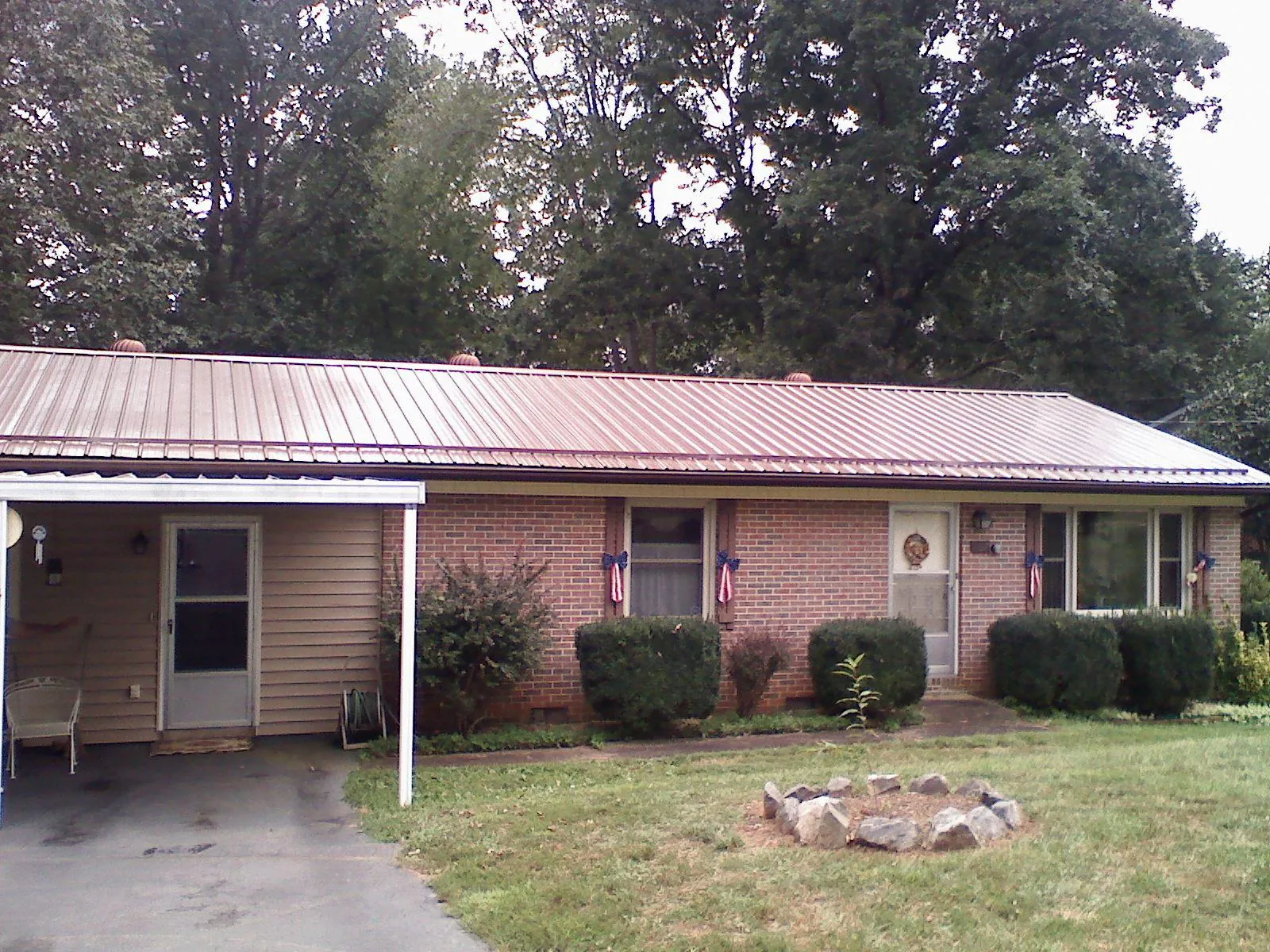 Bronze metal roof and carport on a brick ranch home — Roof Repair work by our crew in Lisbon Falls